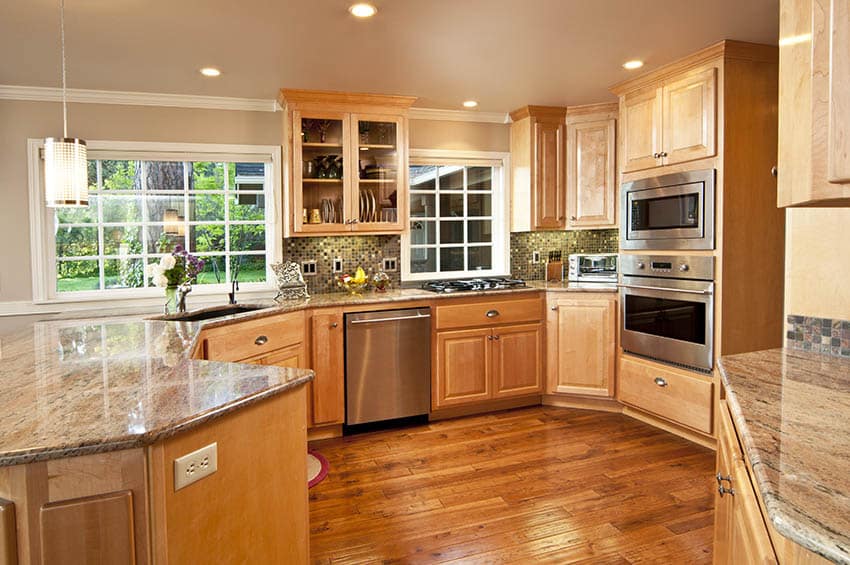 Kitchen with oak cabinets grey mosaic tile backsplash wood flooring