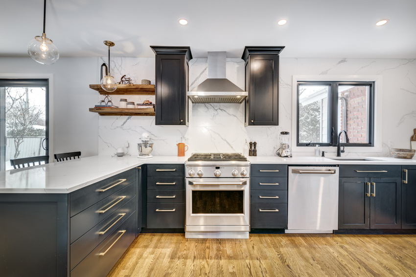 Kitchen with quartz backsplash, dark cabinets, wood floors, and white countertop