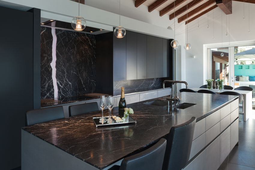 Kitchen with soapstone backsplash, countertop, center island, and pendant lights