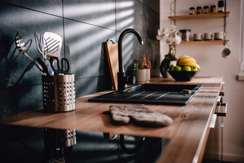 Kitchen with soapstone tile backsplash and wood countertop