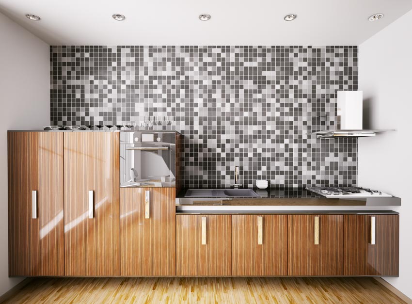 Kitchen with tiled backsplash to ceiling, brown cabinets, and wood floors