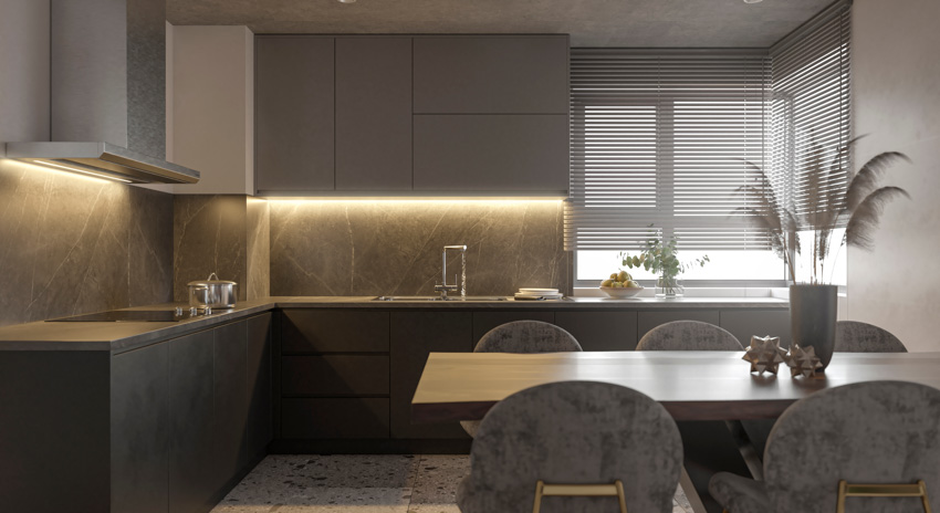 Kitchen with under cabinet lighting, soapstone backsplash, table, and chairs