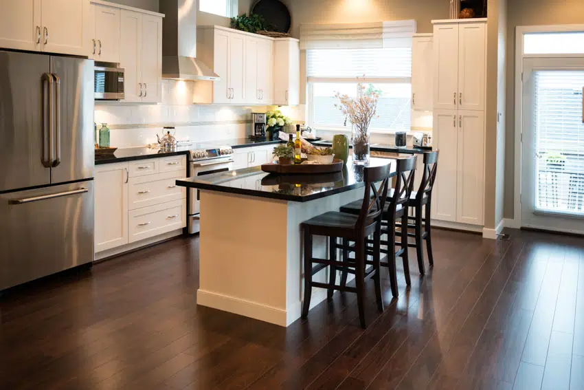 Kitchen with vinyl floor, center island, countertop, windows, white cabinets, and high chairs