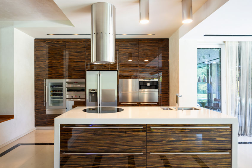 Kitchen with wine cooler, refrigerator, center island, countertop, range hood, and cabinets