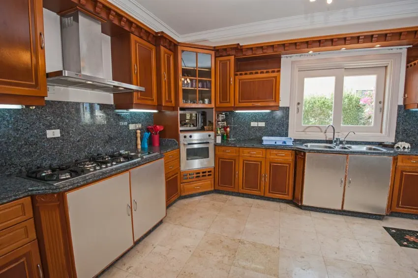 Kitchen with wood cabinets, tile floor, labradorite countertop, and backsplash
