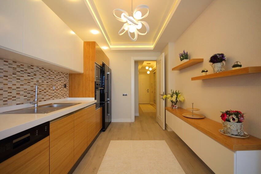 Kitchen with wood floor, glossy black appliances, chandelier and open shelves 