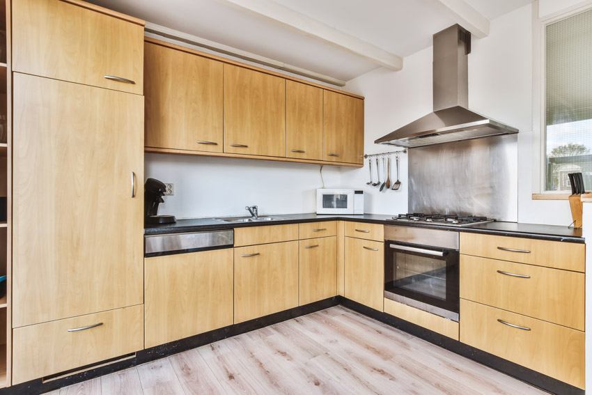 Kitchen with wood floor, oak cabinets, stove, and range hood