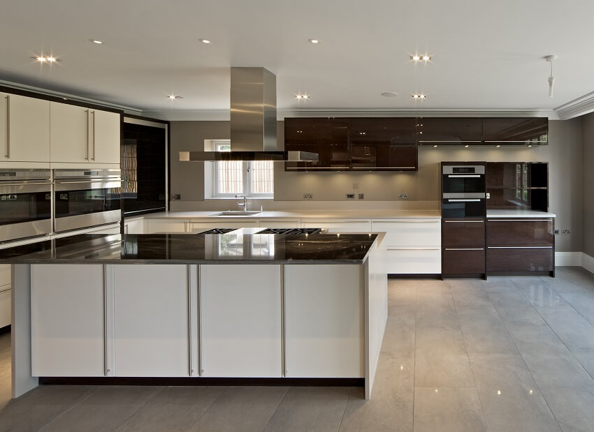 Large empty kitchen with glossy brown cabinet, tile floors and grey walls