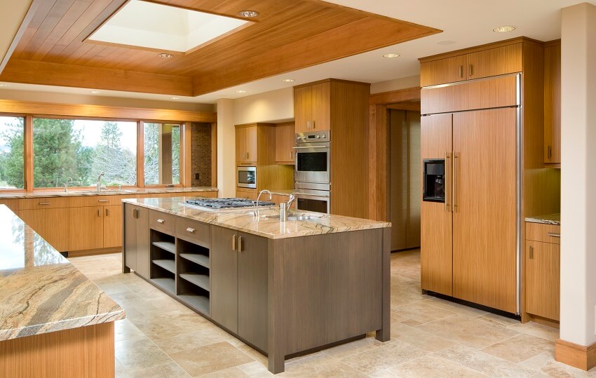 Large kitchen with bamboo cabinets marble countertops tile floors stainless steel appliances wood panel ceiling accent and a center island sink and cooktop