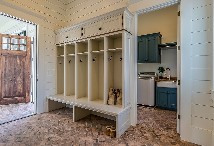 Laundry room and mudroom combo shiplap walls brick tile flooring cubbyholes and bench