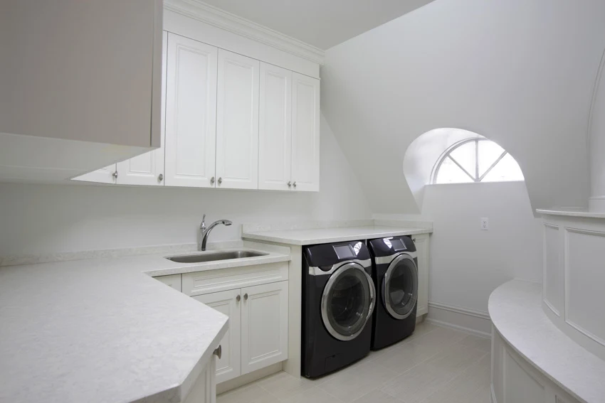 Laundry room white cabinets countertop sink window