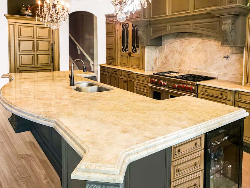 Limestone countertop in kitchen with center island, hood, backsplash, and wood floor
