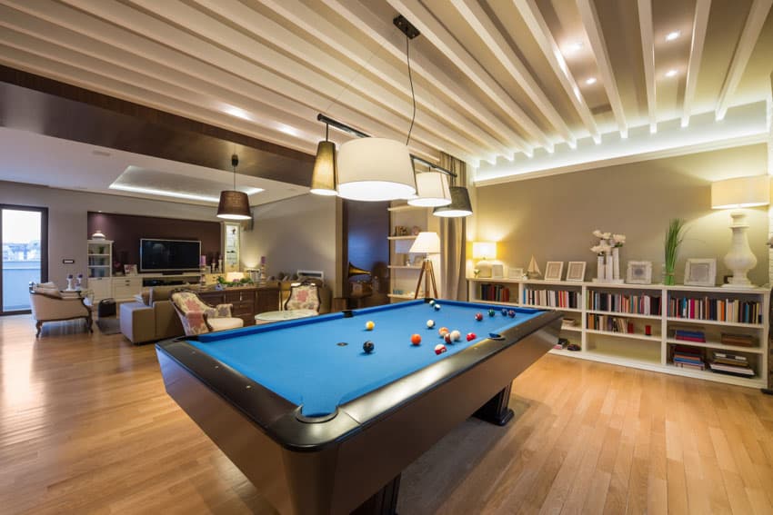 Living room with beautiful ceiling, pendant light, pool table, wood floor, open cabinet, couch, and window