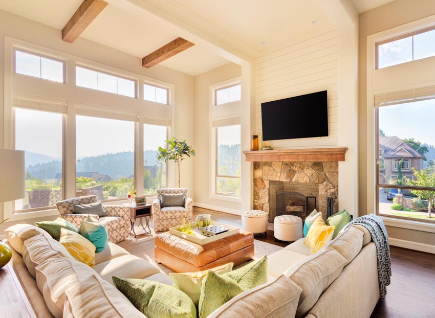 Living room with modern transom windows, sofa, fireplace, and wood beams