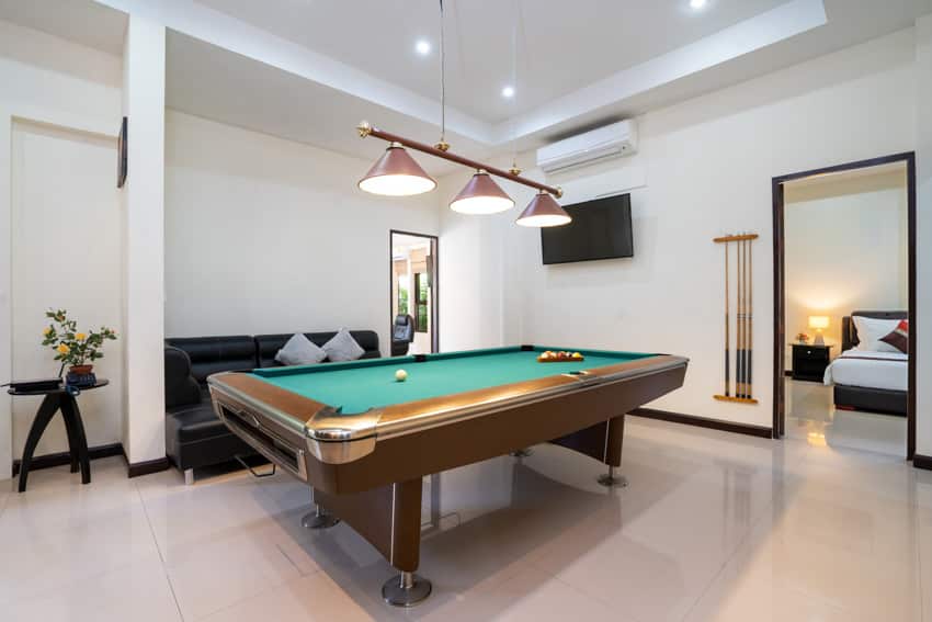 Living room with pendant lights, pool table, tray ceiling, and tile floor