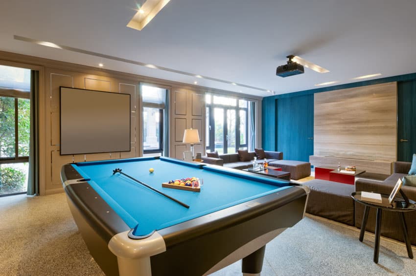 Living room with pool table, wood accent wall, couch, and recessed lights