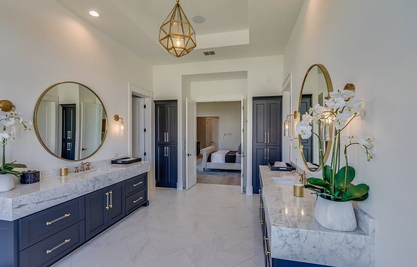 Master bathroom with symmetrical vanity areas with blue cabinets quartz countertops and silver and brass knobs