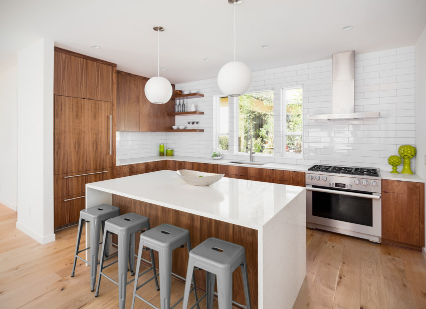 Minimalist kitchen with center island, tiled backsplash, high chairs, pendant lights, cabinets, and wood floor