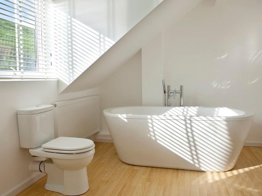 bathroom with free standing bathtub, wood floor, and toilet 