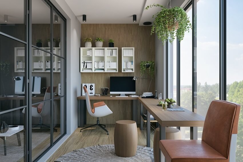 Modern home office with L-shpaed wood desk white shelves plants large windows white and brown chairs wood floors and brown wall background