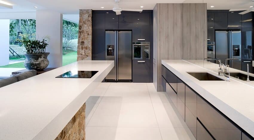 Kitchen with a large mirror, island with a stone base and white countertops