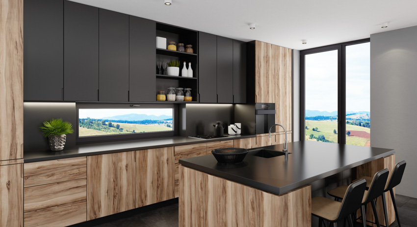 Modern kitchen with black wood cabinets, center island, and windows