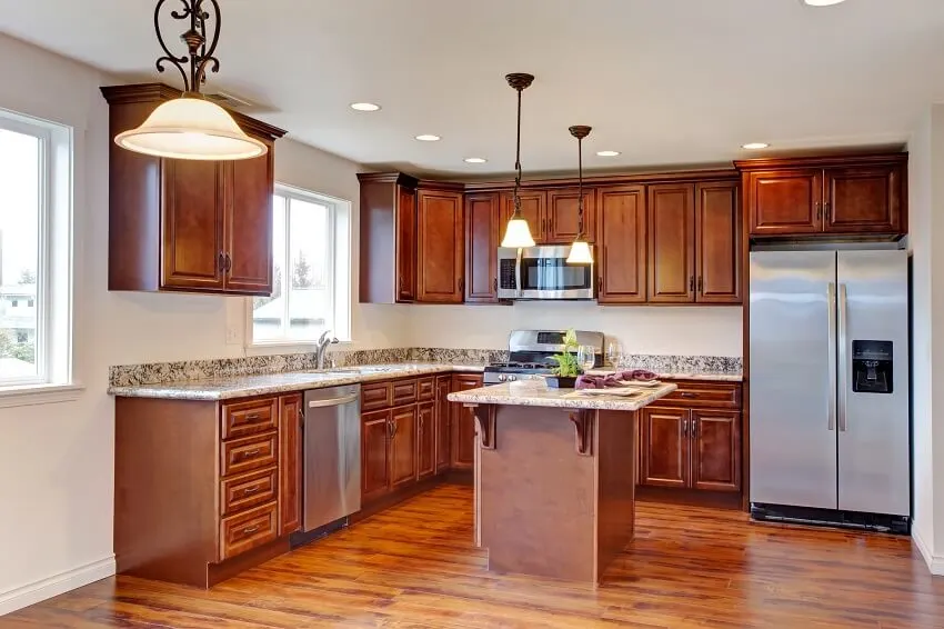 Modern kitchen with hardwood floor cherry cabinets island hanging lights appliances and granite countertops