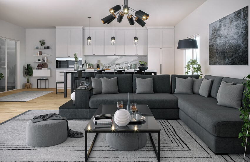 Open space kitchen with dark grey sofa and white kitchen storage spaces