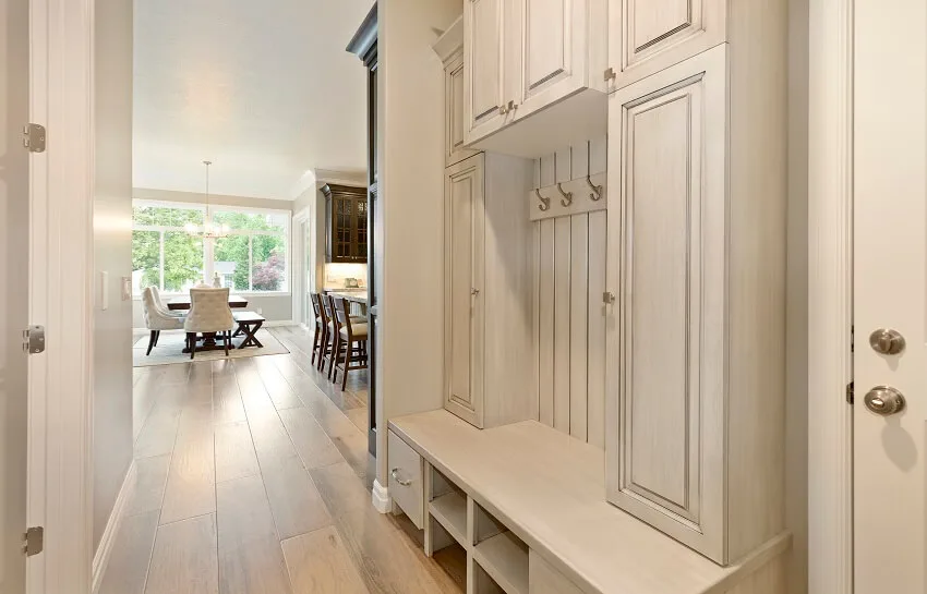 White cabinets with panel doors, cubbies under shelves and white floors