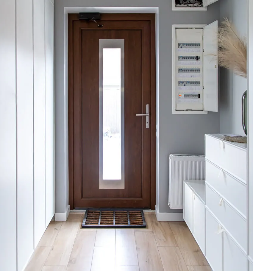 Entrance door made of wood, white drawers with white circuit box