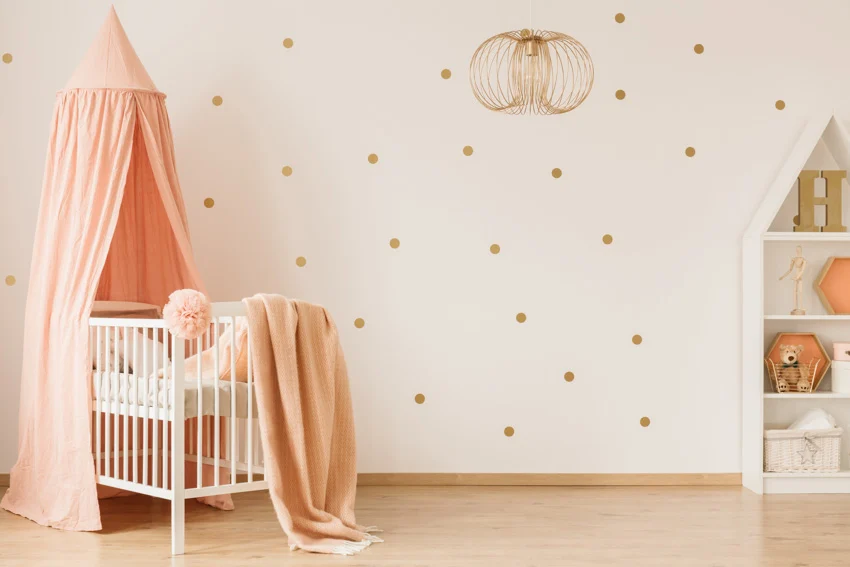 Nursery room with patterned wall, crib, and wood flooring