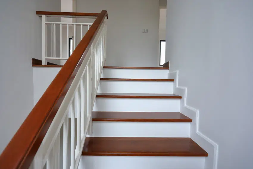 Stairs leading to basement with white staircase wall