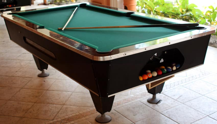 Pool table with cue sticks and balls stored in a drawer