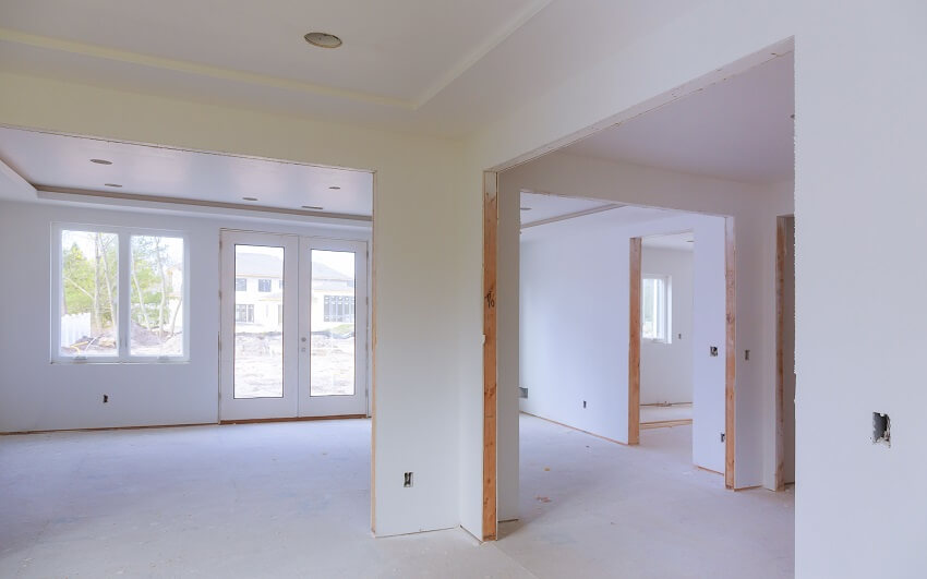 Room interior with french doors windows and drywall installed in a new house under construction