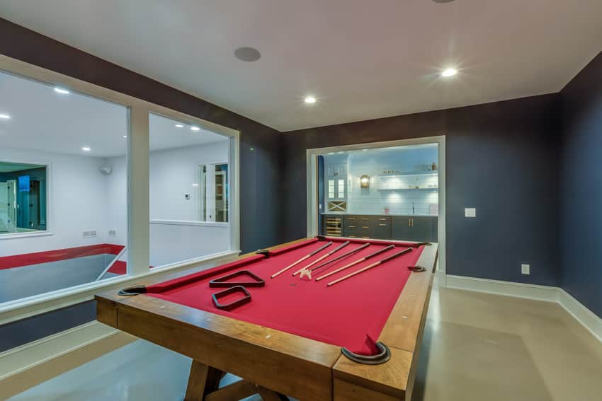 Room with big glass windows, pool table, and recessed lighting