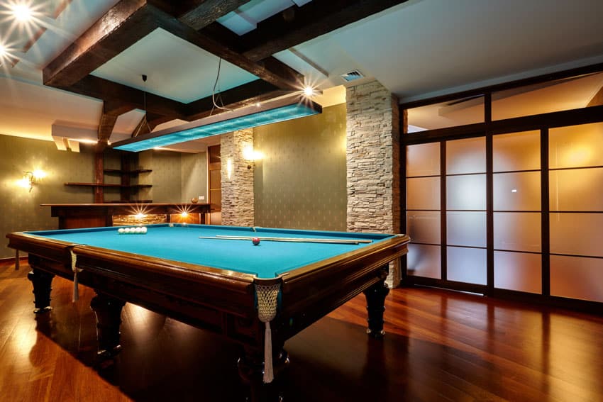 Room with dark wood floor, hanging light, and pool table