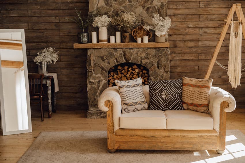 Rustic room with accent wall made of wood, couch, and fireplace