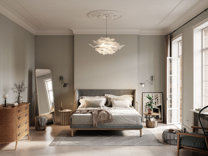 Simple bedroom with gray walls, windows, pendant light, mirror, dresser, bed, and windows