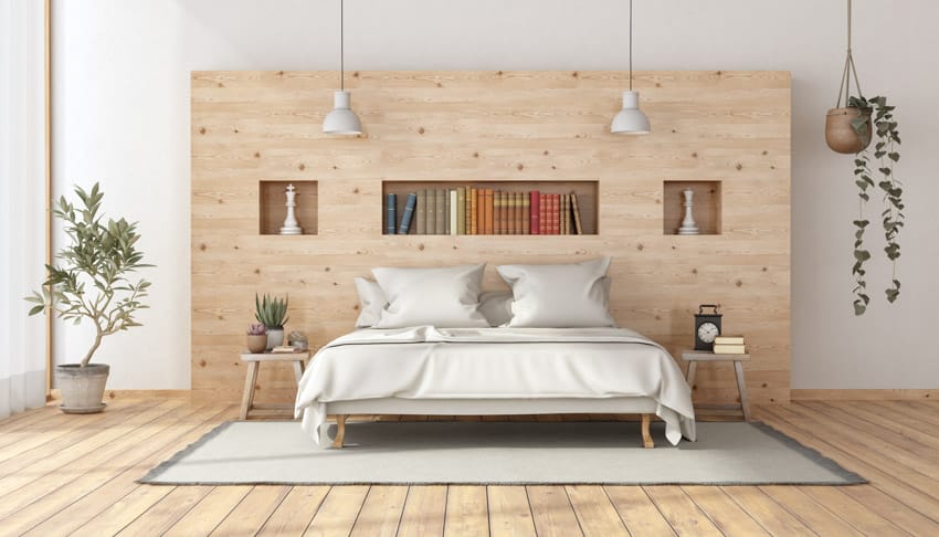 Spacious bedroom with light wood accent wall, recessed shelves, indoor plant, bed, and nightstands