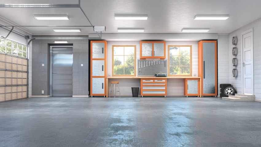 Spacious garage with concrete flooring, workstation, and door opener