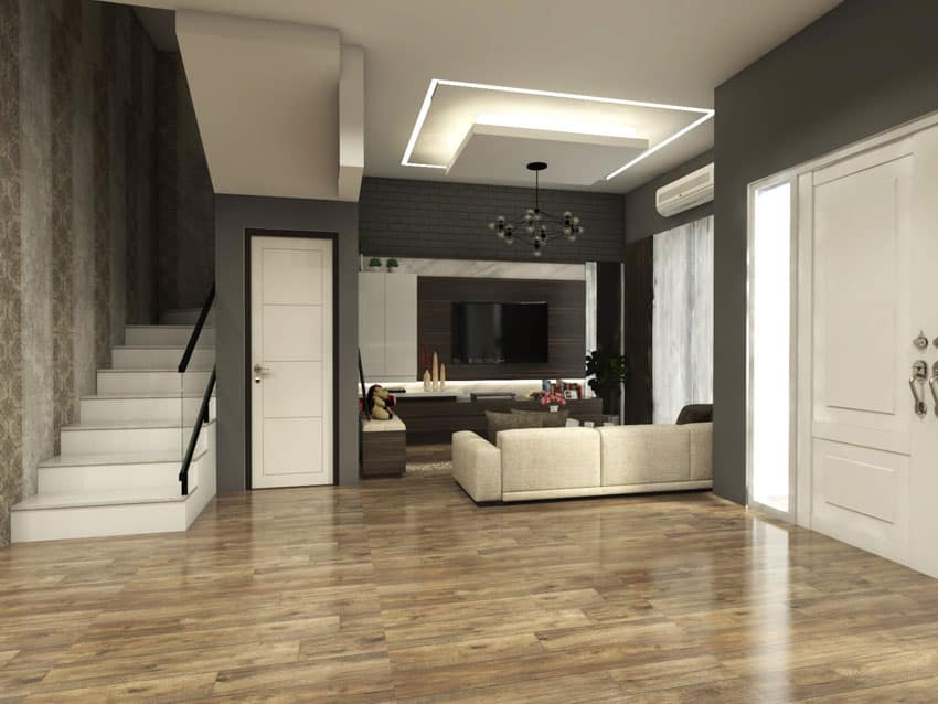 Spacious home interior with vinyl floor, white door, staircase, and living room