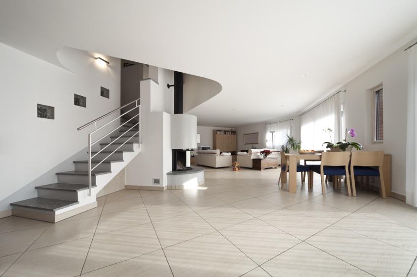 Expansive room with staircase, high ceiling and large ceramic tile