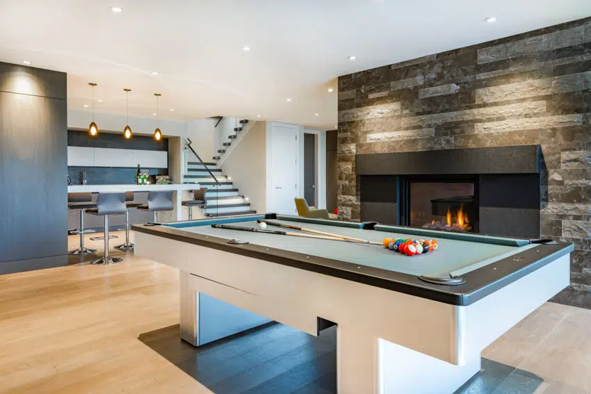Spacious entertainment room with fireplace, table, and bar area