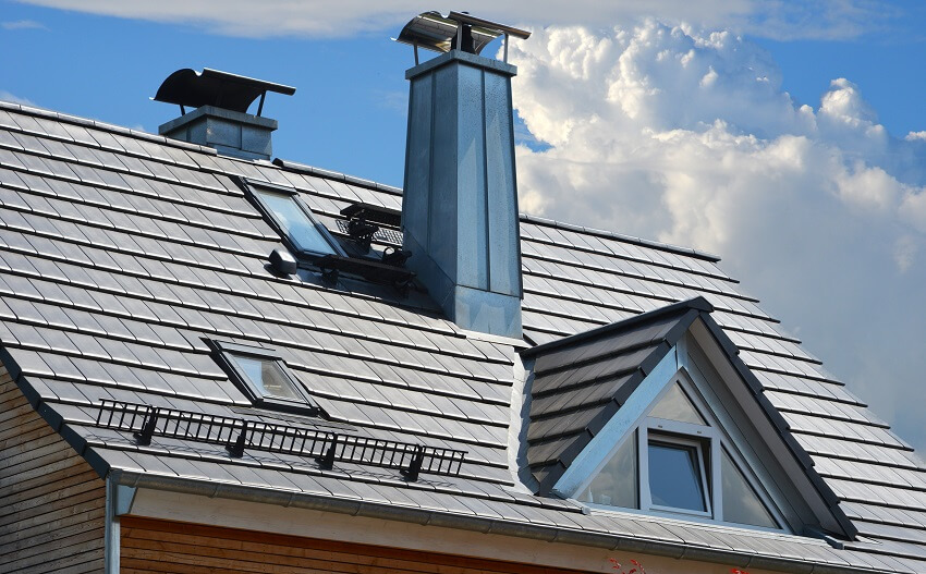 Standing seam steel chimneys with high grade steel cap skylight windows snow guard and dormer window at a grey tiled roof