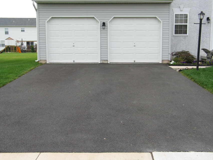 Tar and chip driveway leading to garage doors