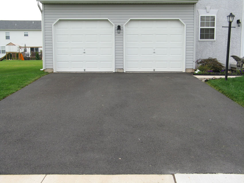 Driveway leading to white garage doors