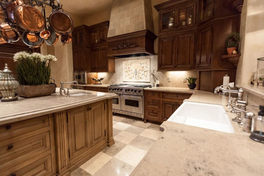 Tuscan style kitchen with limestone countertops, center island, dark wood cabinets, hood, and tile floors