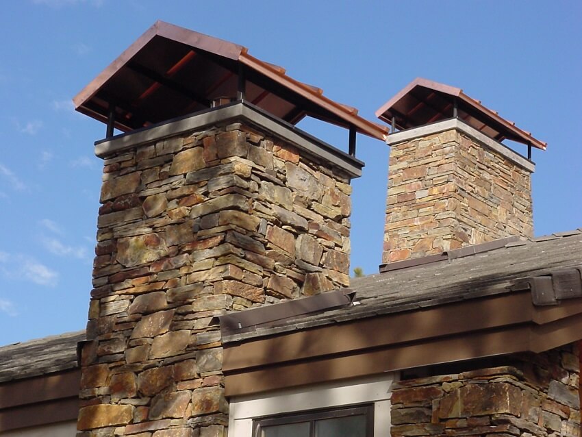 Two stone chimneys with caps