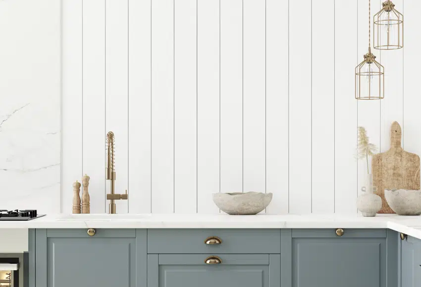 White sideing with gray drawers and brass faucet