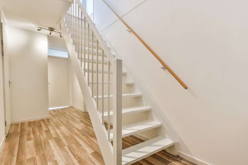 White painted basement stairs and wooden flooring